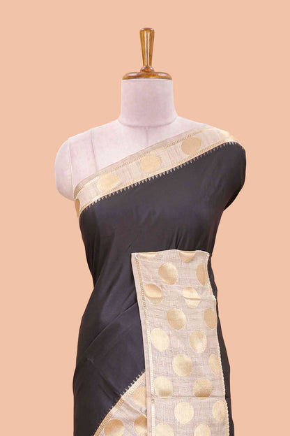 Black art tussar saree with plain body, cream coin motif zari border and zig-zag printed pallu