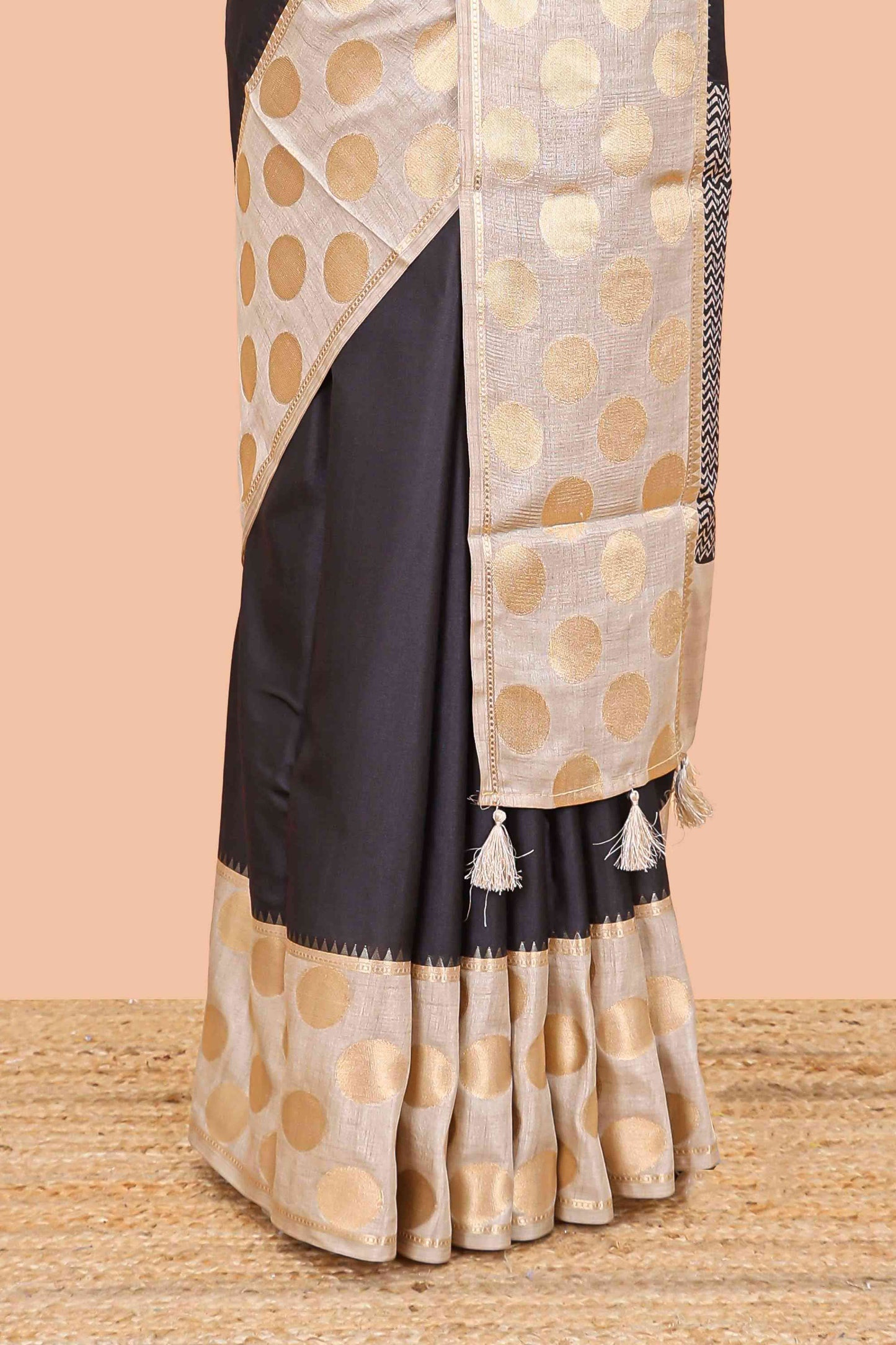 Black art tussar saree with plain body, cream coin motif zari border and zig-zag printed pallu