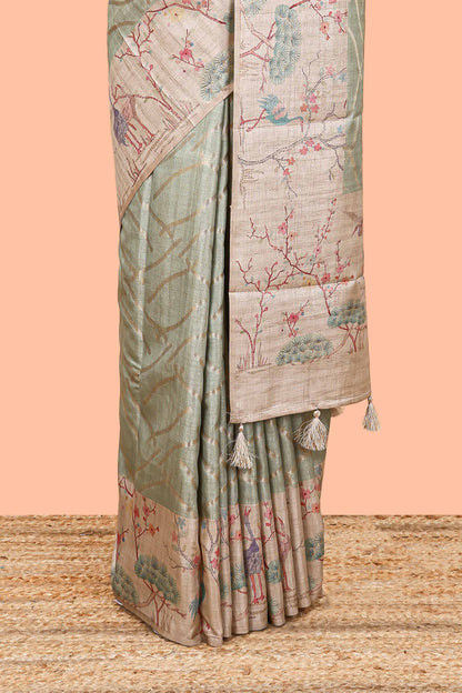 Green art tussar saree with wave zari weaving body and cream nature print border & pallu