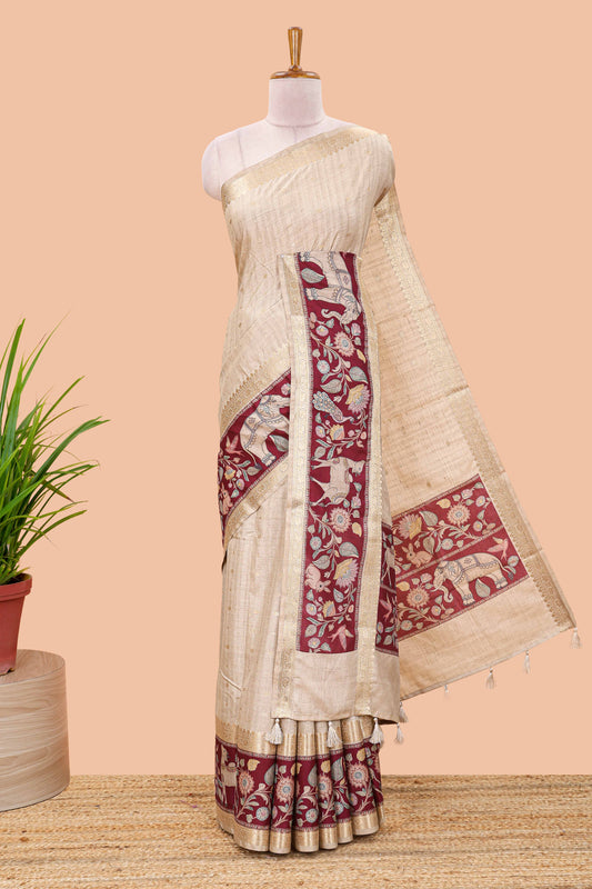 Beige art tussar silk saree featuring zari butta and maroon retta-patta border with kalamkari animal designs