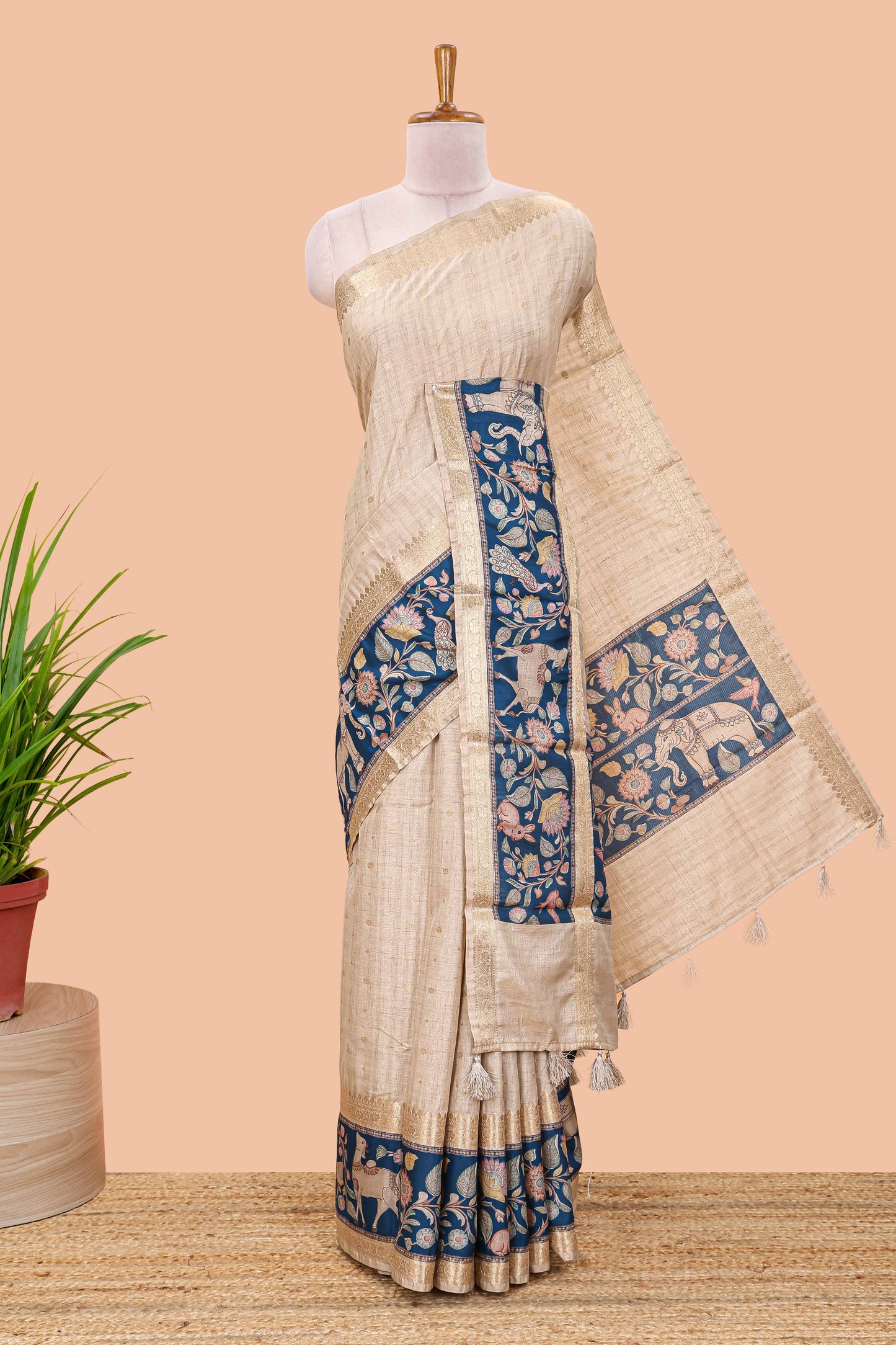 Beige art tussar silk saree featuring zari butta and blue retta-patta border with kalamkari animal designs
