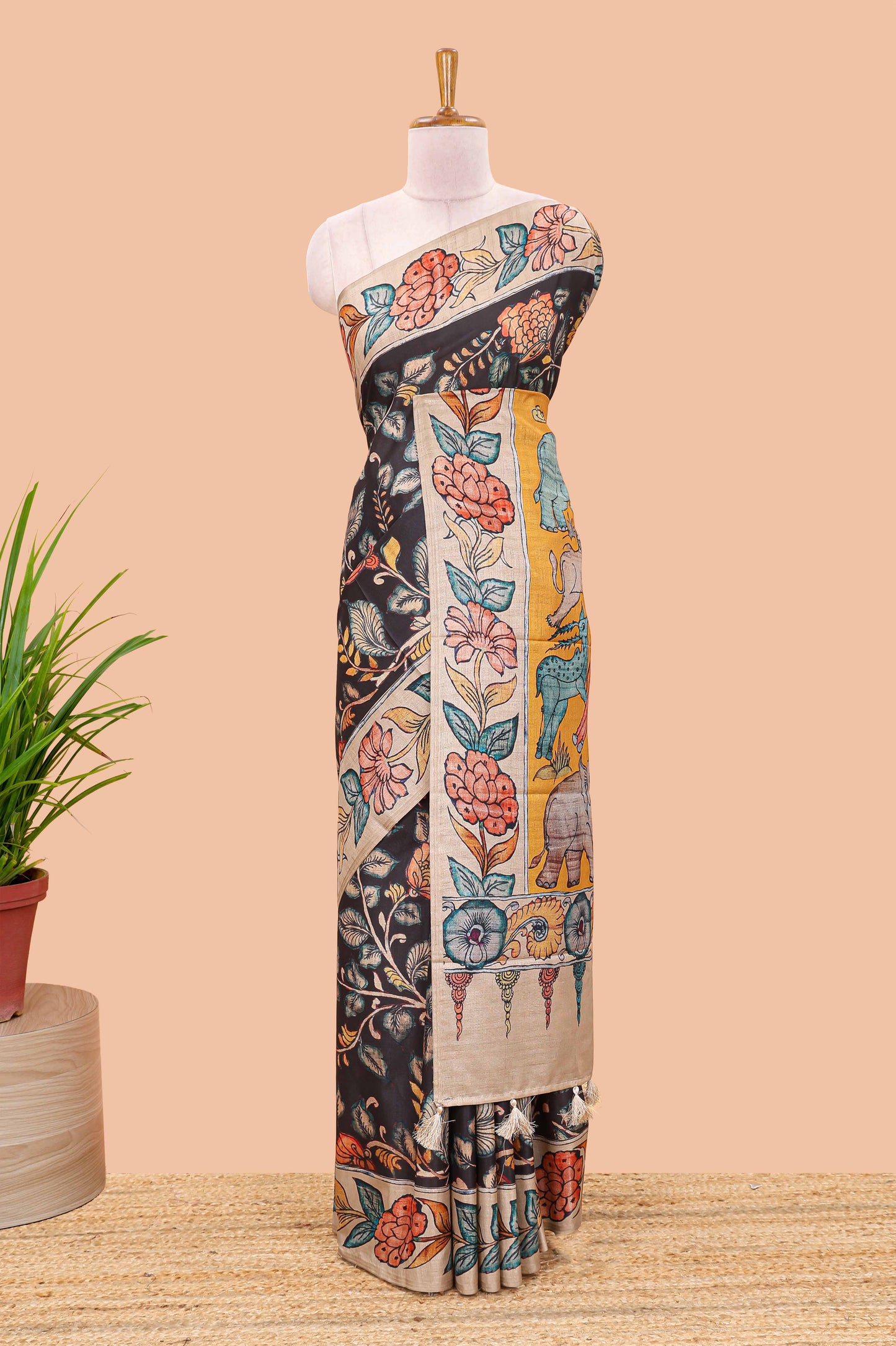 Black art tussar silk saree with leaf and floral printed body, cream border, and floral & animal print pallu