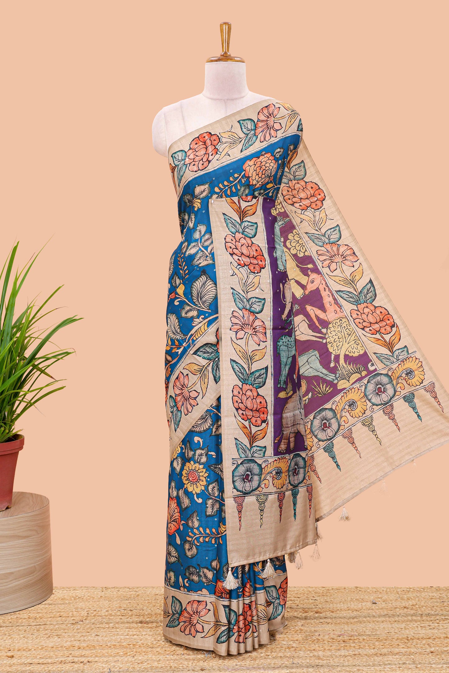 Blue art tussar silk saree with leaf and floral printed body, cream border, and floral & animal print pallu