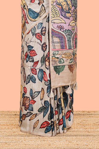 Borderless beige art tussar saree with tree, bird motifs and dancing girl printed pallu