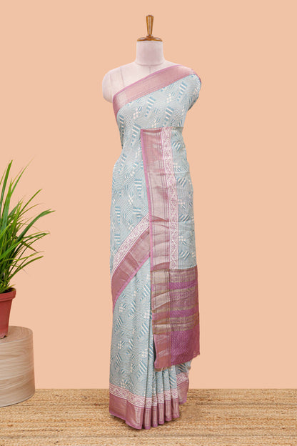 Turquoise blue assam silk saree with geometric print body, contrast zari border, and zari stripe pallu