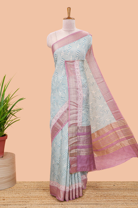 Turquoise blue assam silk saree with geometric print body, contrast zari border, and zari stripe pallu