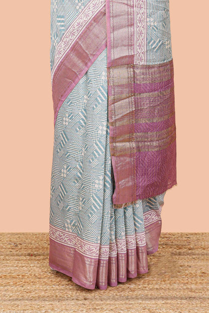 Turquoise blue assam silk saree with geometric print body, contrast zari border, and zari stripe pallu
