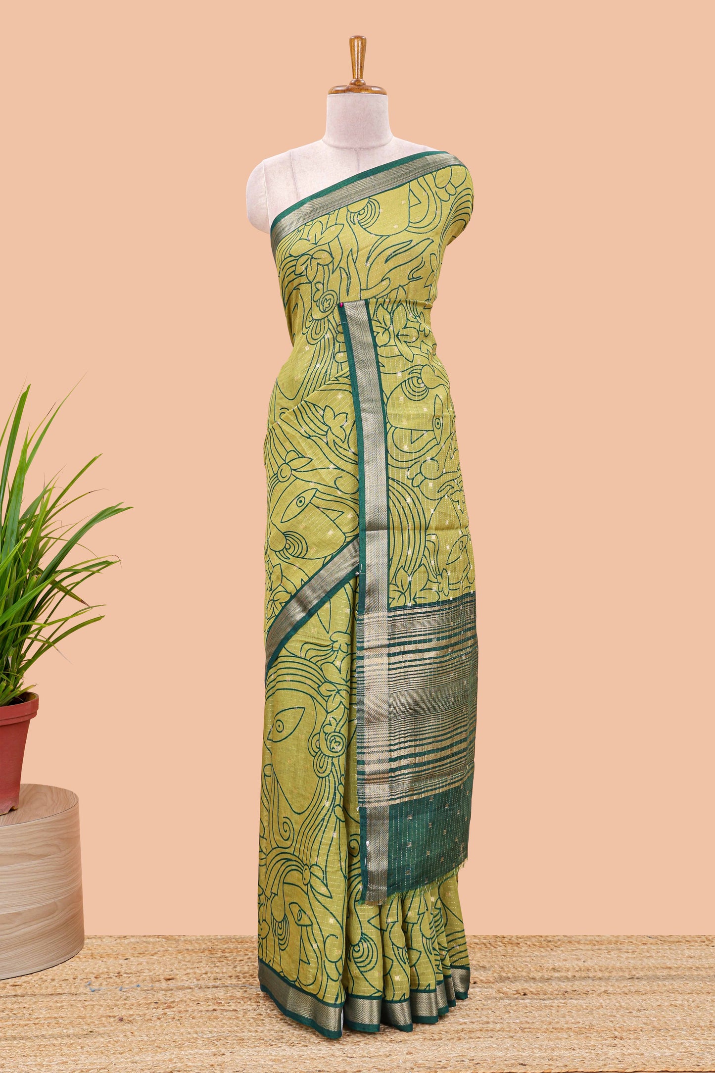 Green assam silk abstract face print saree with contrast zari border and pallu