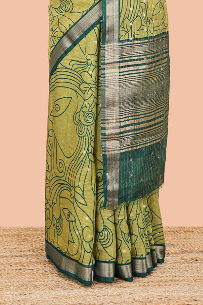 Green assam silk abstract face print saree with contrast zari border and pallu