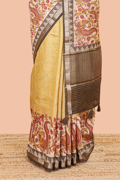 Mustard assam silk saree with zari check, floral & peacock motifs, kalamkari print border and striped pallu