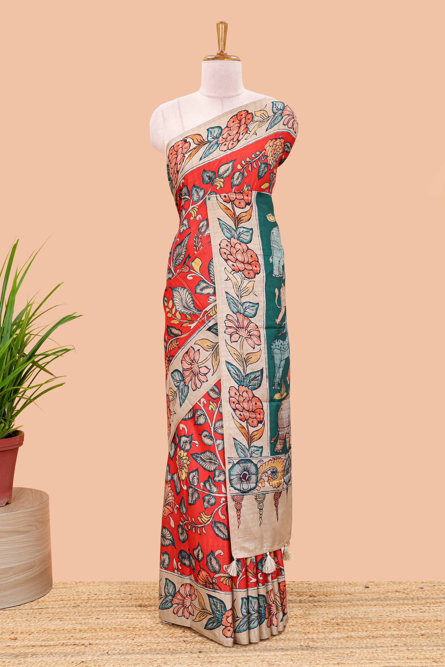 Red art tussar silk saree with leaf and floral printed body, cream border, and floral & animal print pallu