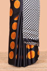 Black satin modal saree with orange polka print, contrast checked pallu, and printed blouse