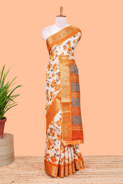 Cream floral design semi dola silk saree with contrast orange zari border an blouse