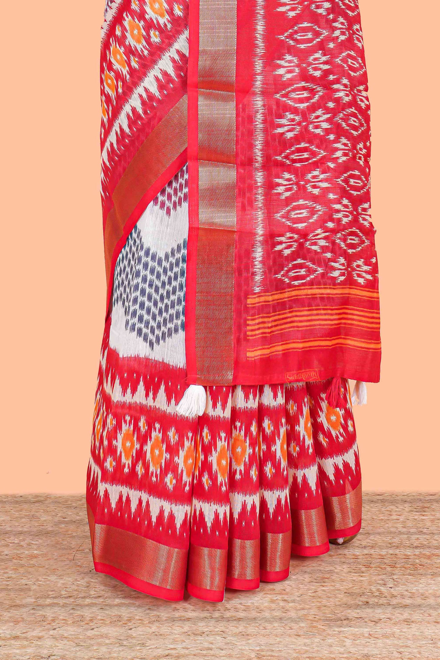 White geomentric ikkat style linen cotton saree with contrast orange border and pallu