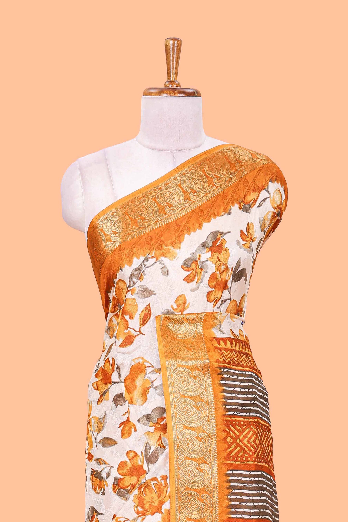 Cream floral design semi dola silk saree with contrast orange zari border an blouse