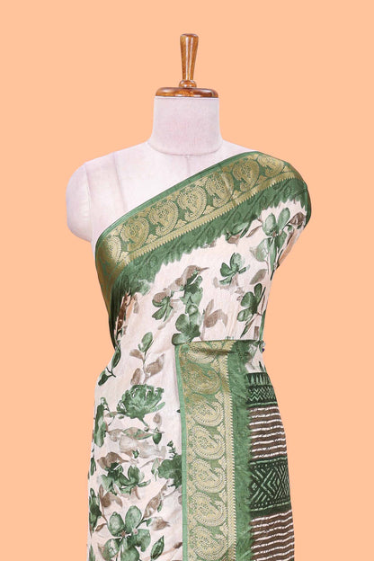 Cream floral design semi dola silk saree with contrast green zari border an blouse