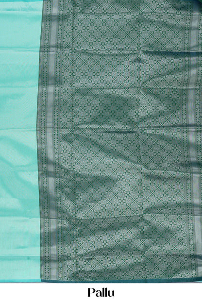 Teal  green lichi silk saree with a patterned pallu on a light blue background 