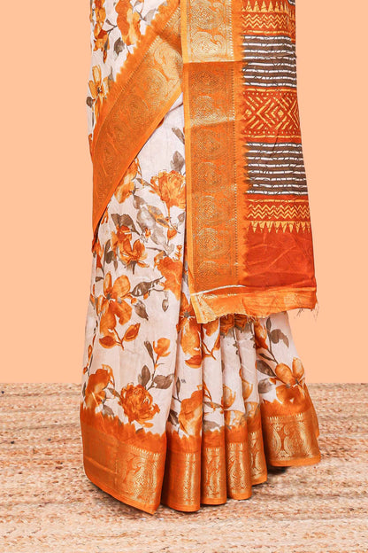 Cream floral design semi dola silk saree with contrast orange zari border an blouse