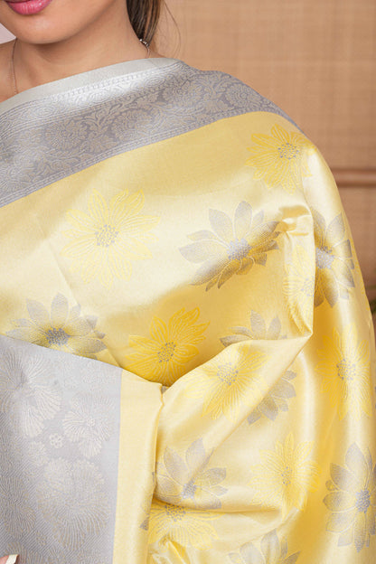 yellow tissue saree with silver pallu