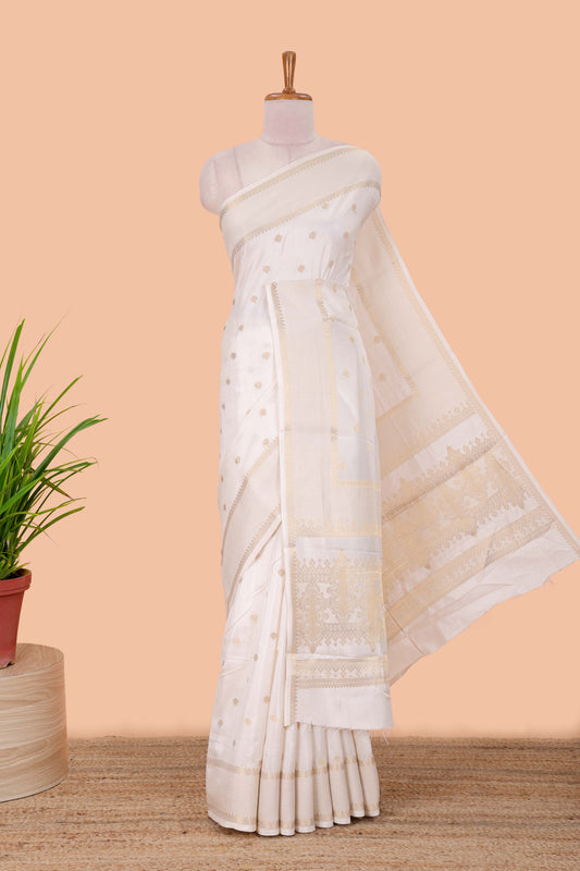 White dola silk saree with all over zari butta, bendex zari border, rich zari pallu and contrast blouse