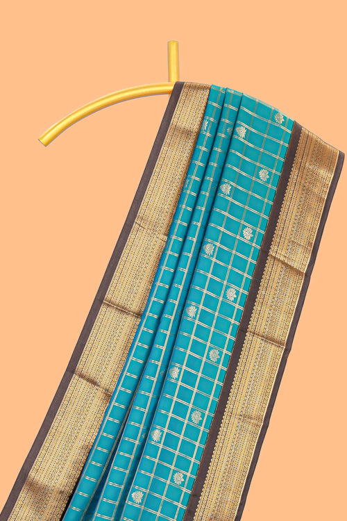 Teal blue checked art silk saree with contrast zari border and striped blouse