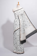 Elegant white Assam Silk saree traditional folk motif print floral patterns and a contrast black woven border The detailed pallu along with contrast blouse