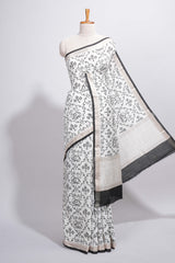 Elegant white Assam Silk saree traditional folk motif print floral patterns and a contrast black woven border The detailed pallu along with contrast blouse