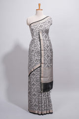 Grey colour Assam Silk saree traditional folk motif print floral patterns and a contrast woven border The detailed pallu along with contrast blouse