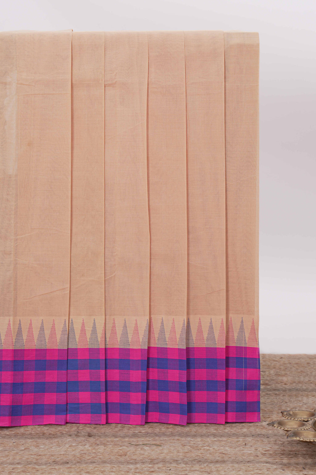 Light Peach Chettinad cotton saree with a plain body contrasting pink and royal blue checked border and classic temple motif detailing along with matching blouse