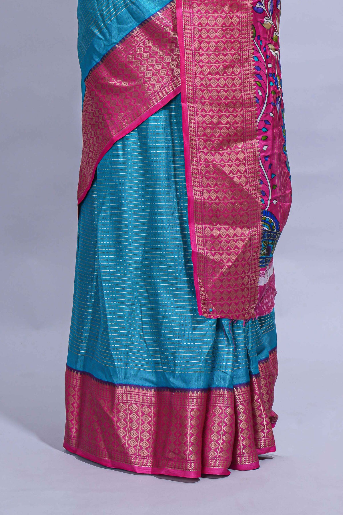 Turquoise blue dola silk saree with fine zari stripes contrast  zari border and a rich peacock floral woven pallu along with printed contrast blouse