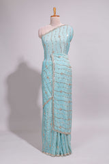Pastel blue saree with silver sequin wavy line embroidery floral motifs and a sparkling embellished border along with matching blouse