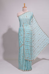 Pastel blue saree with silver sequin wavy line embroidery floral motifs and a sparkling embellished border along with matching blouse