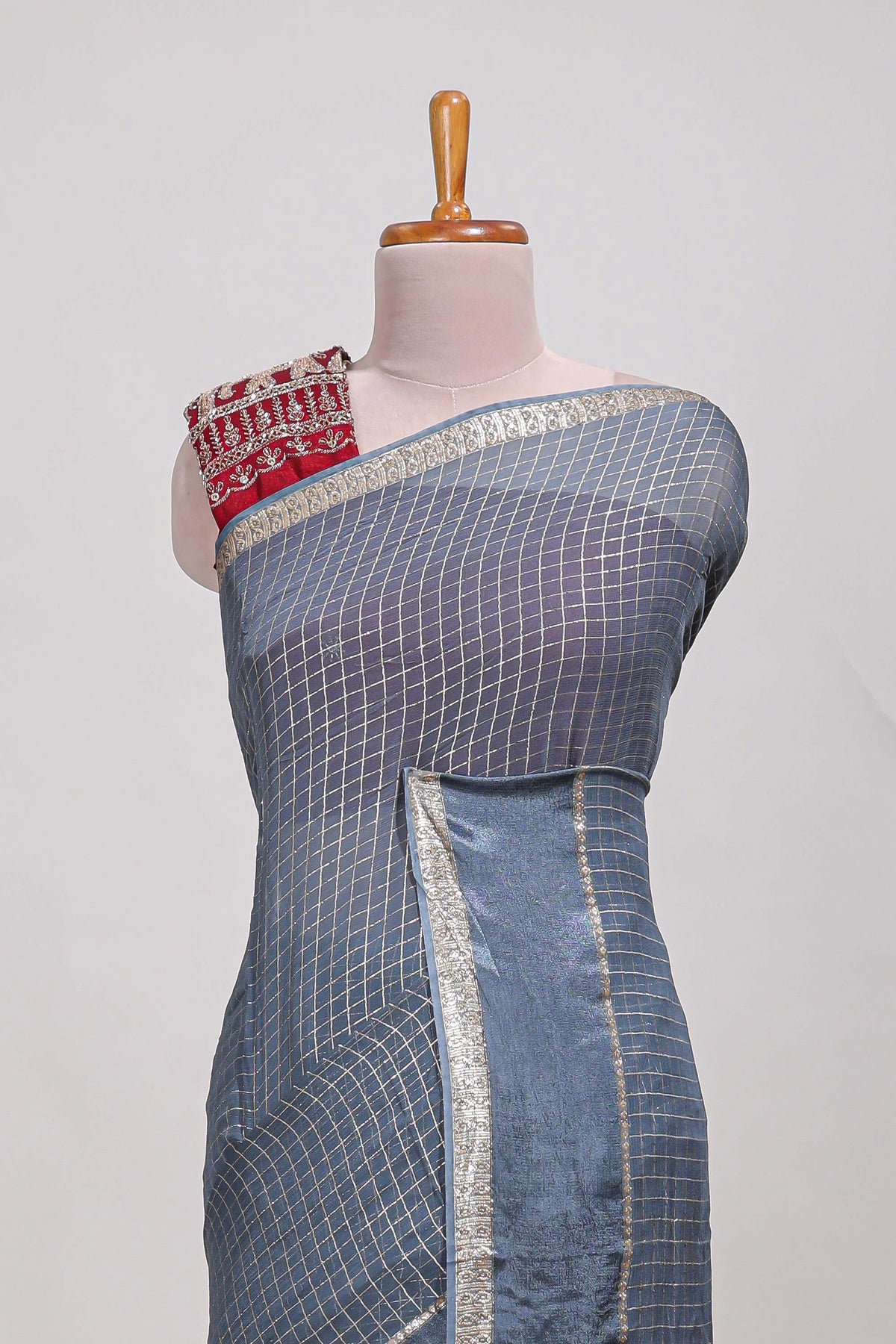 Gray zari checks georgette saree with small zari border and contrast aari work blouse
