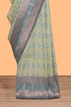 Green geometric motifs design ikkat cotton saree with contrast zari design border and zari floral motifs blouse