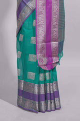 Rama green tussar saree with silver zari square buttas retta petta zari border and woven zari pallu with contrast blouse piece