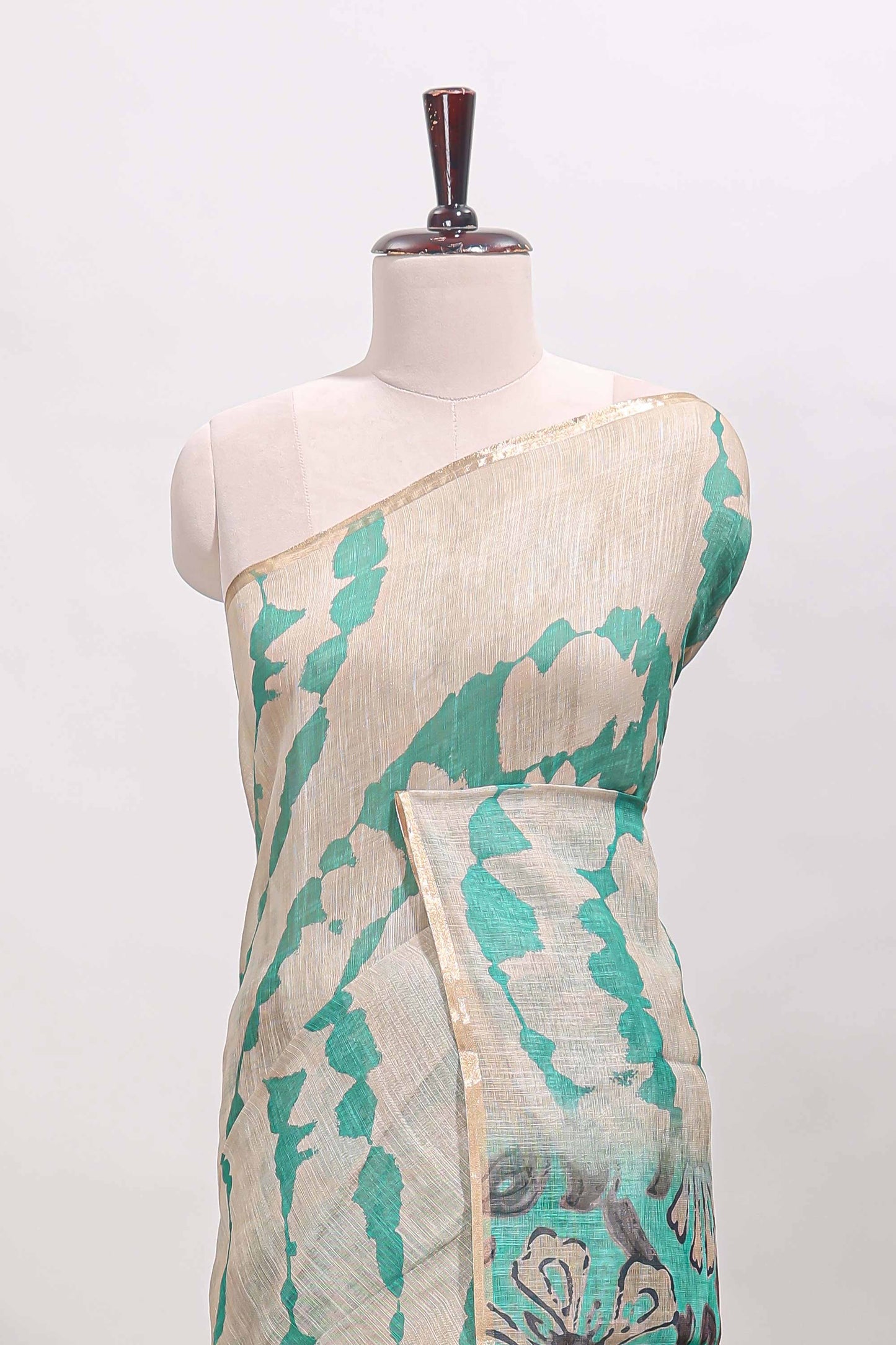 Beige linen cotton saree with green shibori print, self zari border and floral design pallu