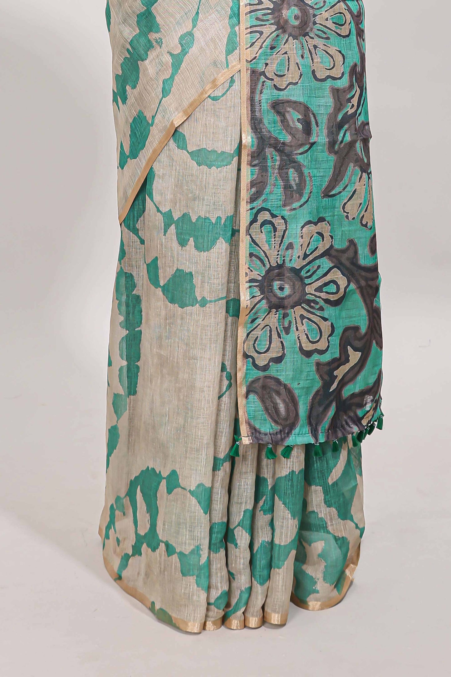 Beige linen cotton saree with green shibori print, self zari border and floral design pallu