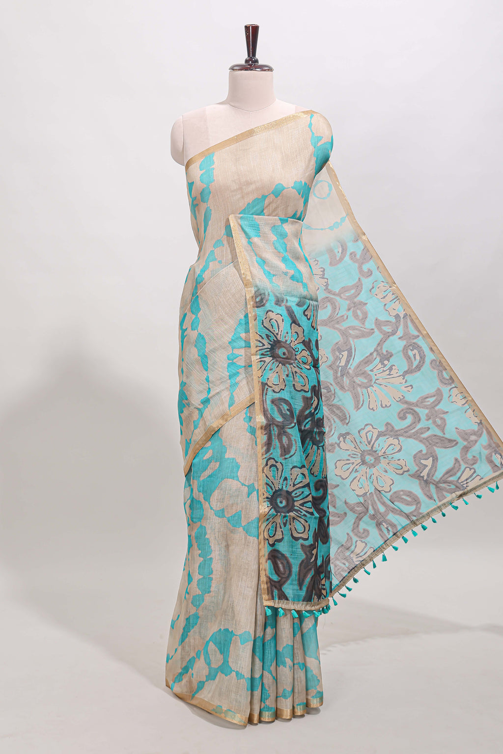 Beige linen cotton saree with blue shibori print, self zari border and floral design pallu