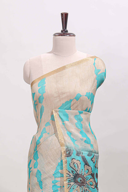 Beige linen cotton saree with blue shibori print, self zari border and floral design pallu