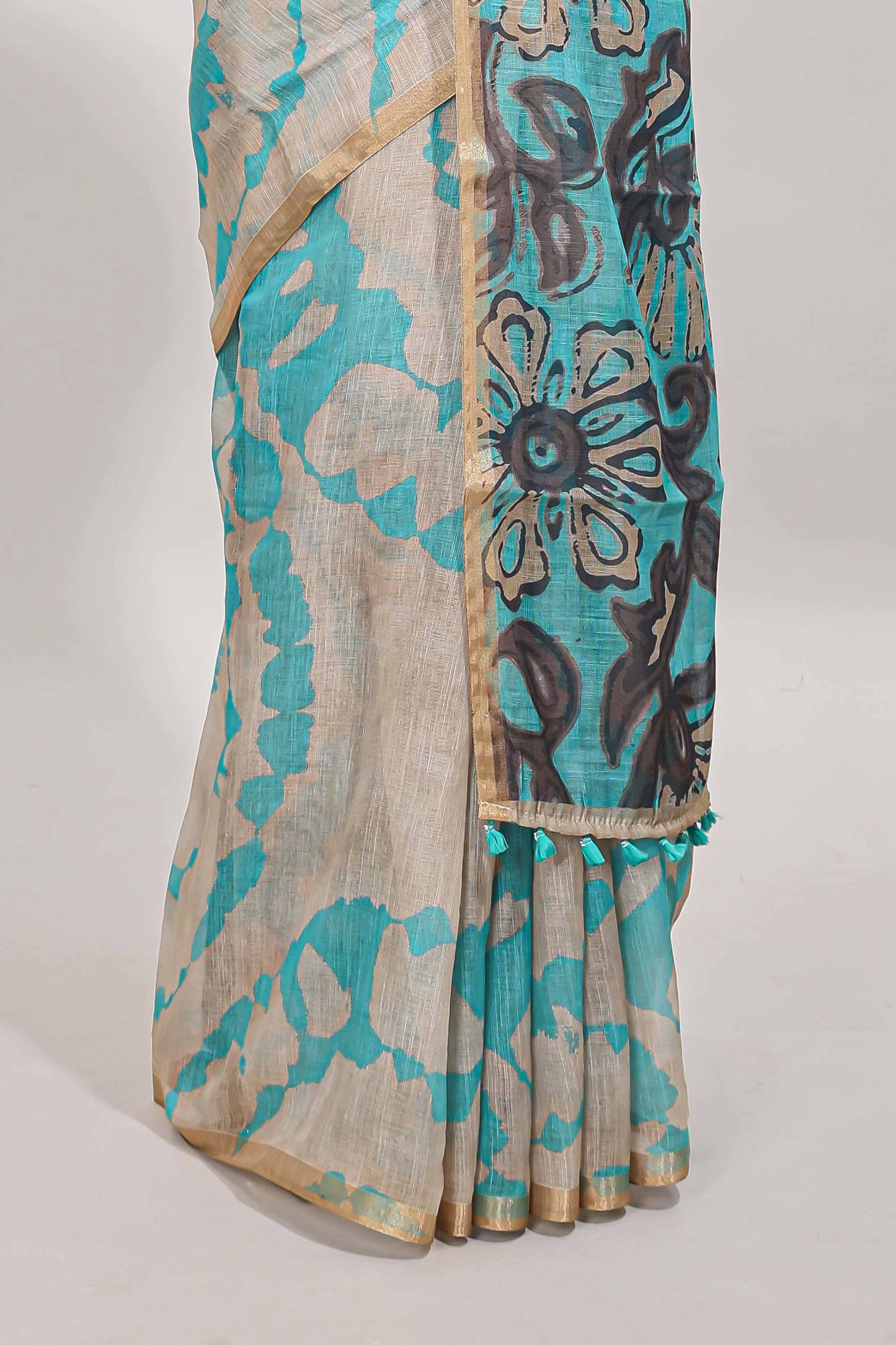 Beige linen cotton saree with blue shibori print, self zari border and floral design pallu