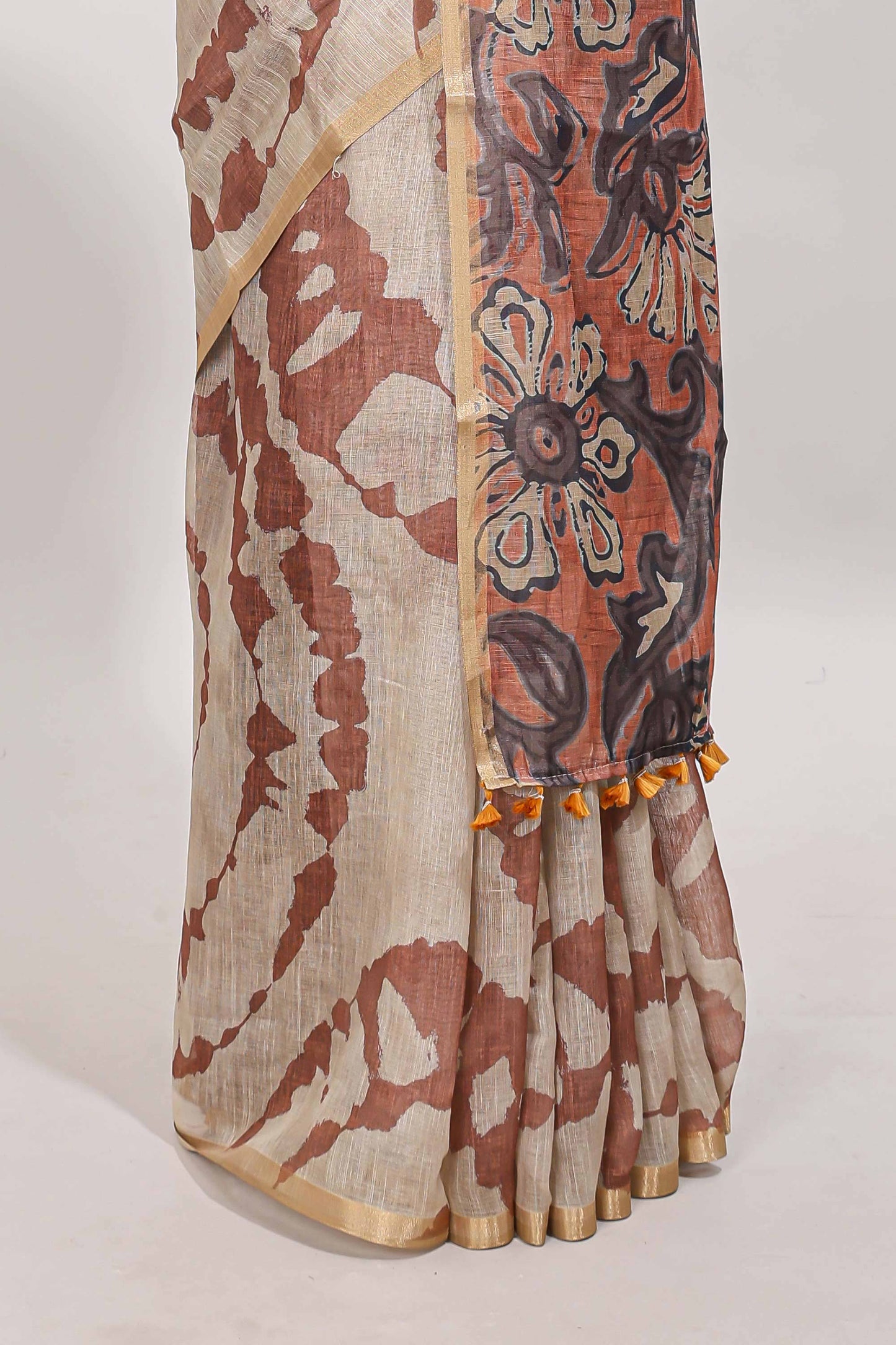 Beige linen cotton saree with brown shibori print, self zari border and floral design pallu