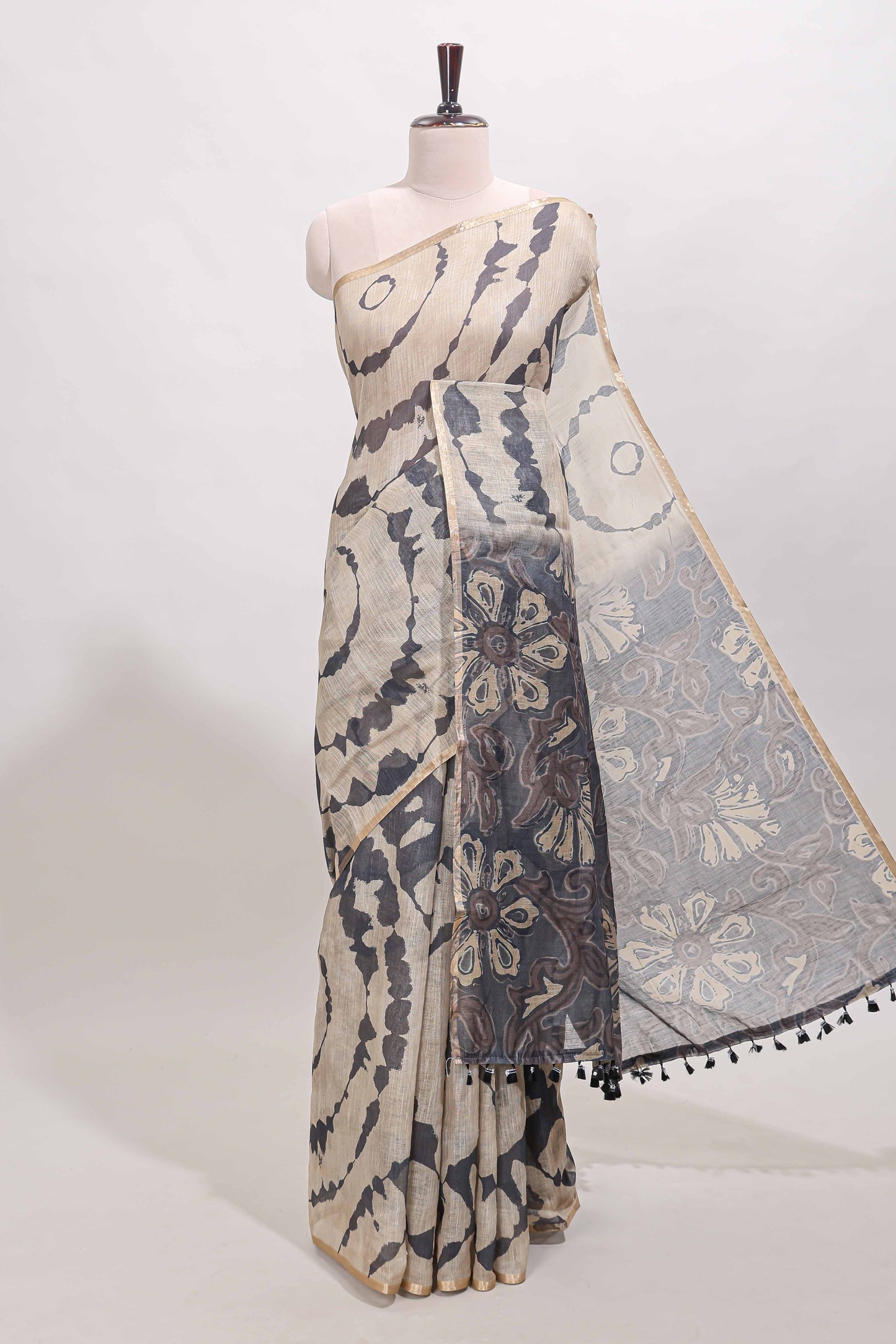 Beige linen cotton saree with grey shibori print, self zari border and floral design pallu