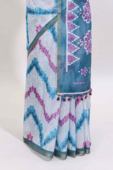 Off white chevron style shibori print linen cotton saree with contrast turquoise blue border and ikkat design pallu