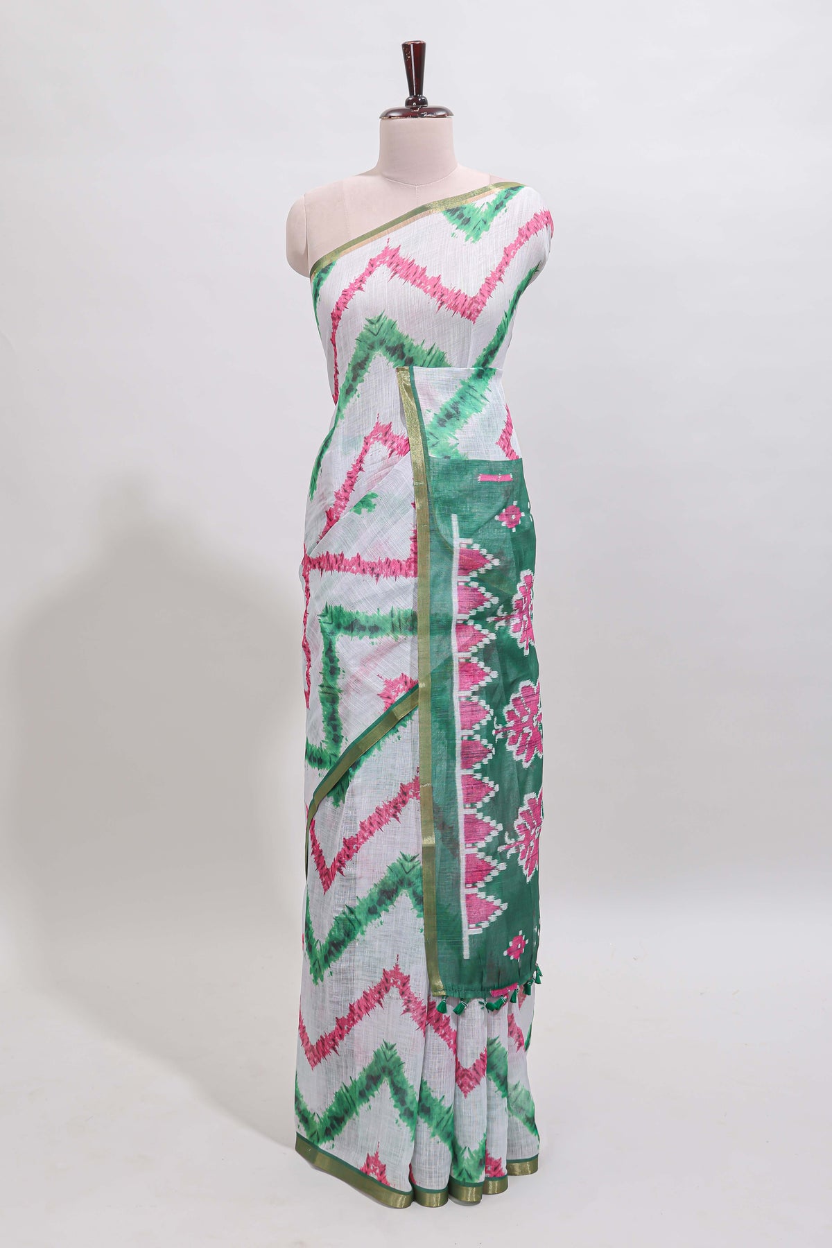 Off white chevron style shibori print linen cotton saree with contrast green border and ikkat design pallu