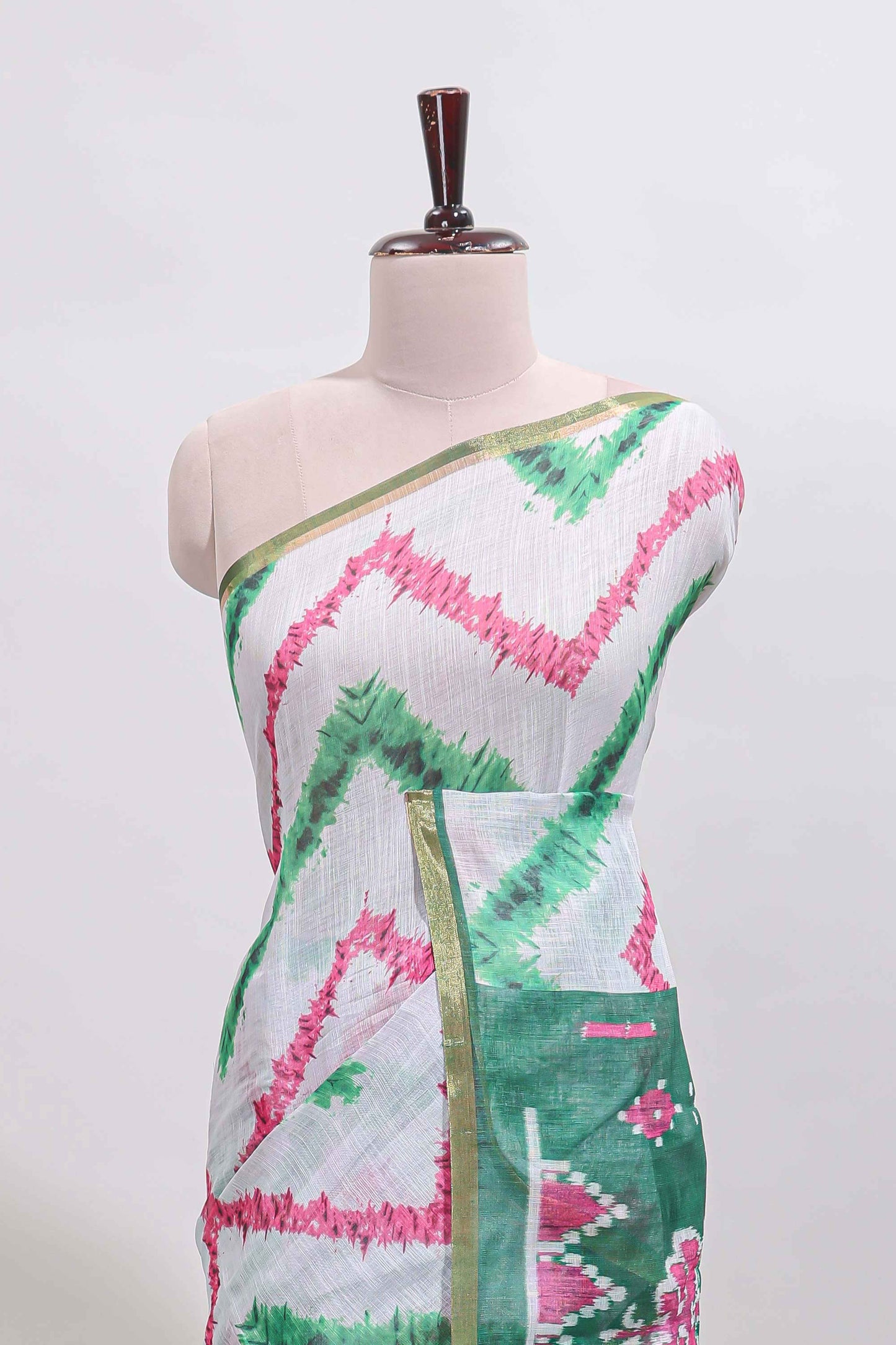 Off white chevron style shibori print linen cotton saree with contrast green border and ikkat design pallu