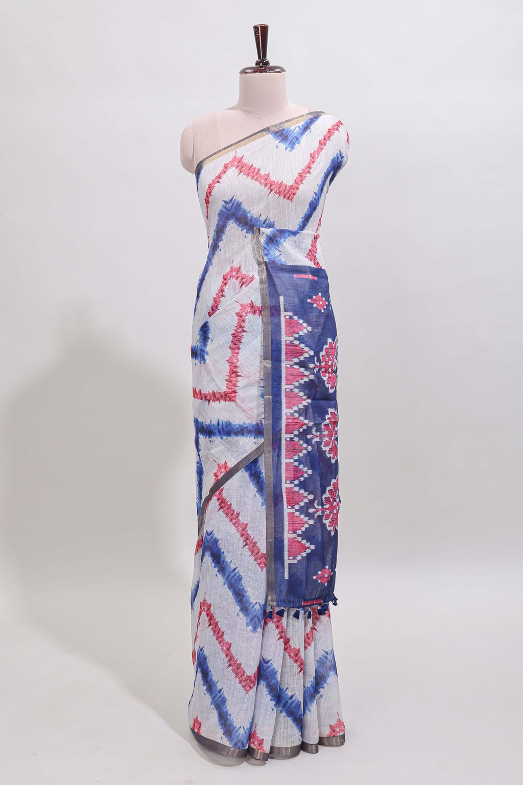Off white chevron style shibori print linen cotton saree with contrast blue border and ikkat design pallu
