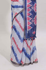 Off white chevron style shibori print linen cotton saree with contrast blue border and ikkat design pallu