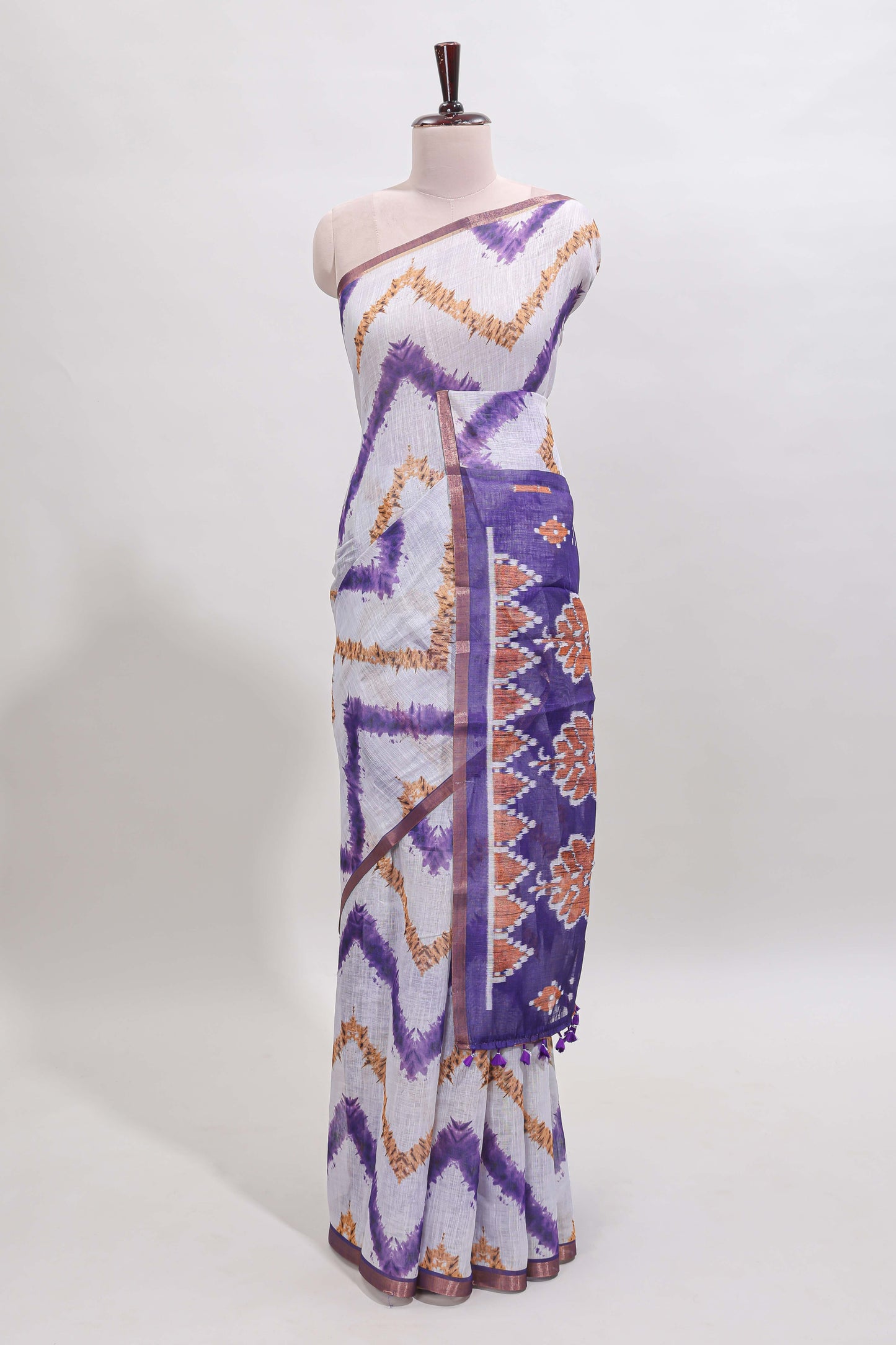 Off white chevron style shibori print linen cotton saree with contrast violet border and ikkat design pallu