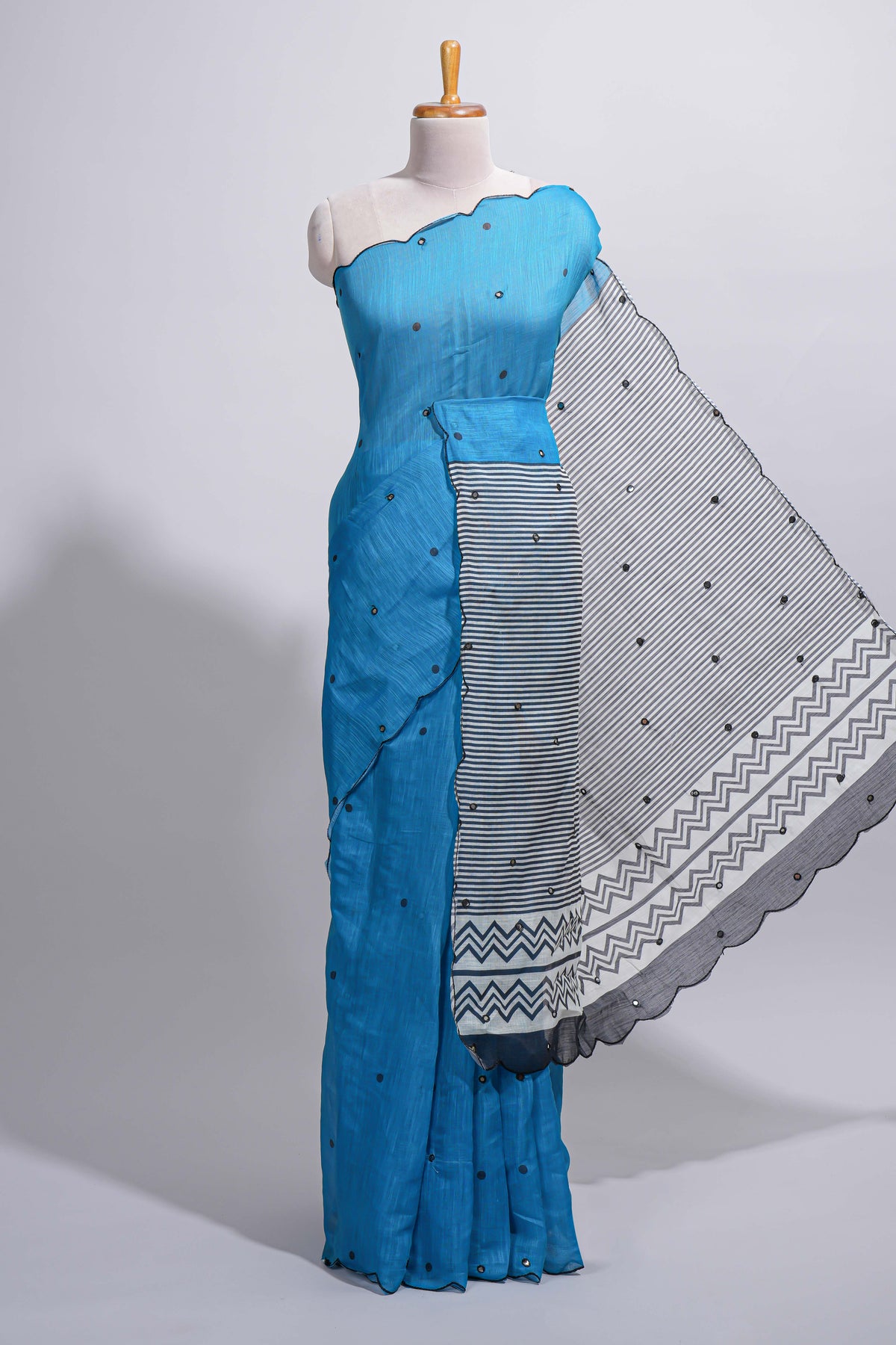 Blue linen cotton saree with  sequin details striped and geometric zigzag pallu with scallop border along with striped blouse