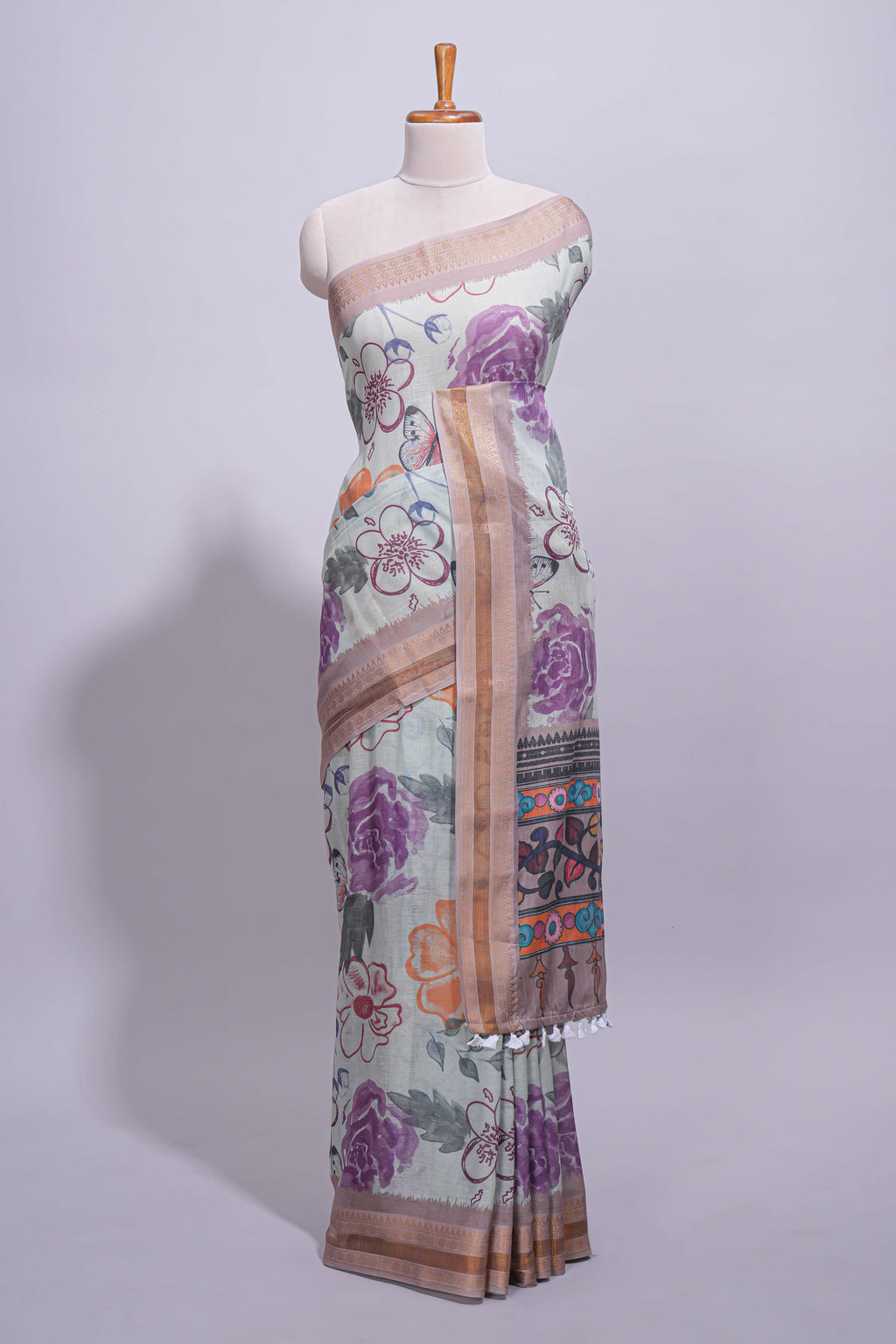 Ivory colour linen saree floral prints with pastel accents by a subtle gold zari border and printed pallu with tassel along with printed blouse